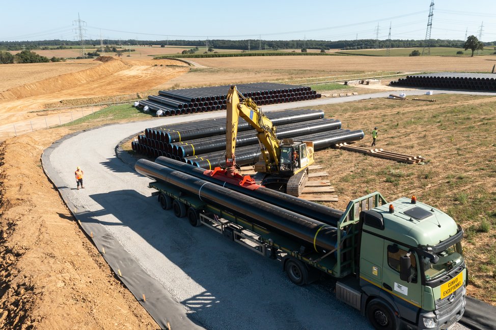 Die Rohre werden vom Rohrlagerplatz von einem Spezialtransporter an die Trasse gebracht.